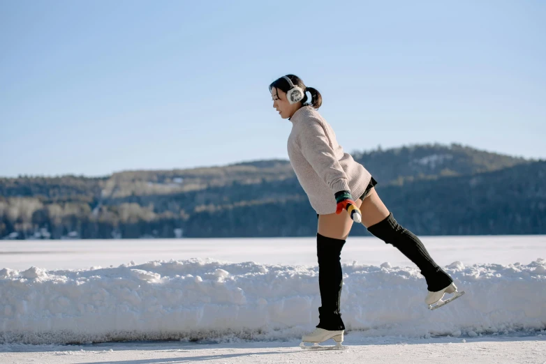 the woman skateboards through the snow on a sunny day