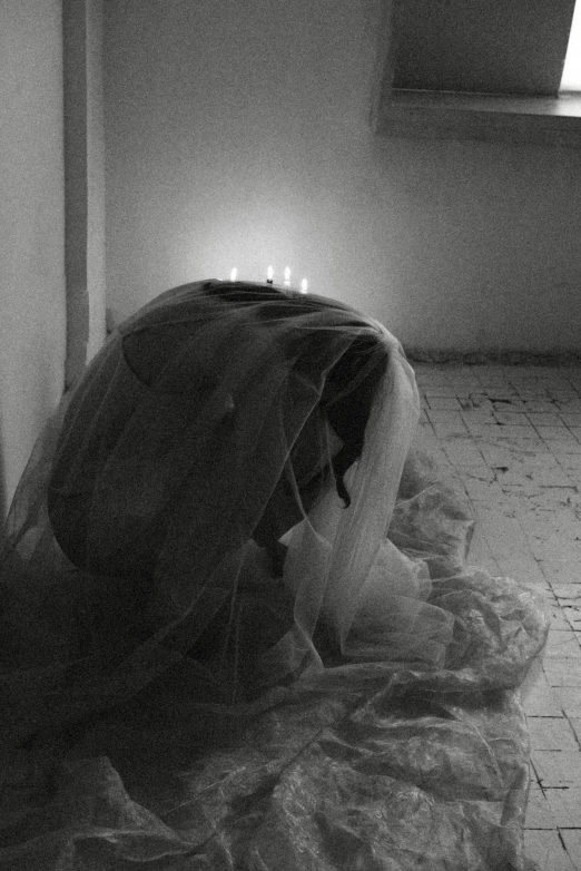 a veiled woman in a black dress is covering the floor