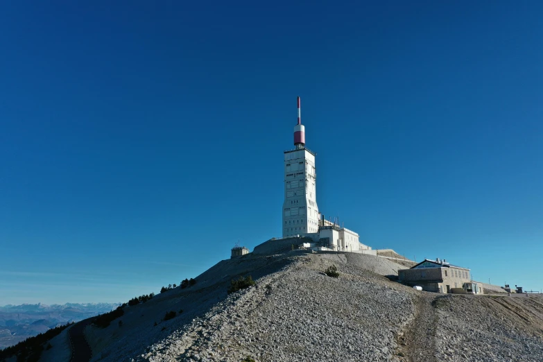 a very large white and grey tower on top of a mountain