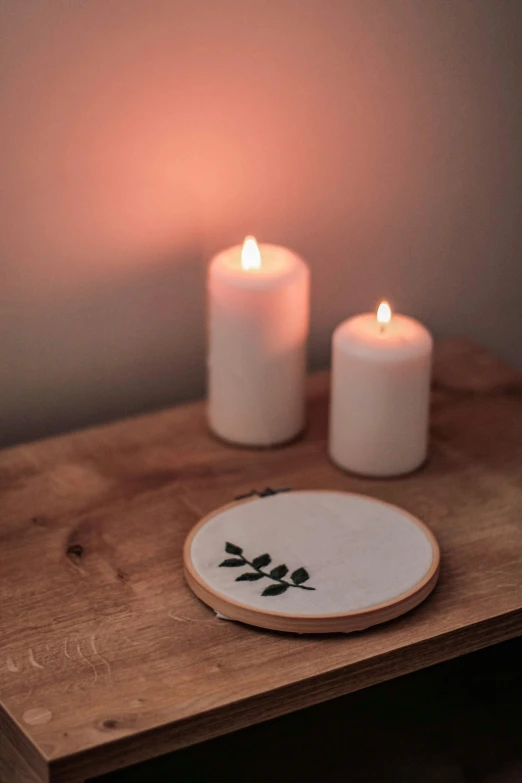 white candles and coaster sit on a table