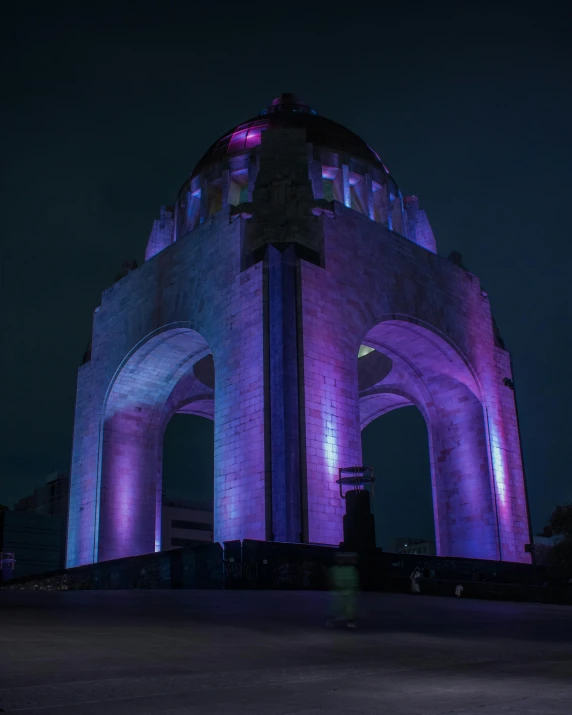 the night view of an illuminated monument in front of a building