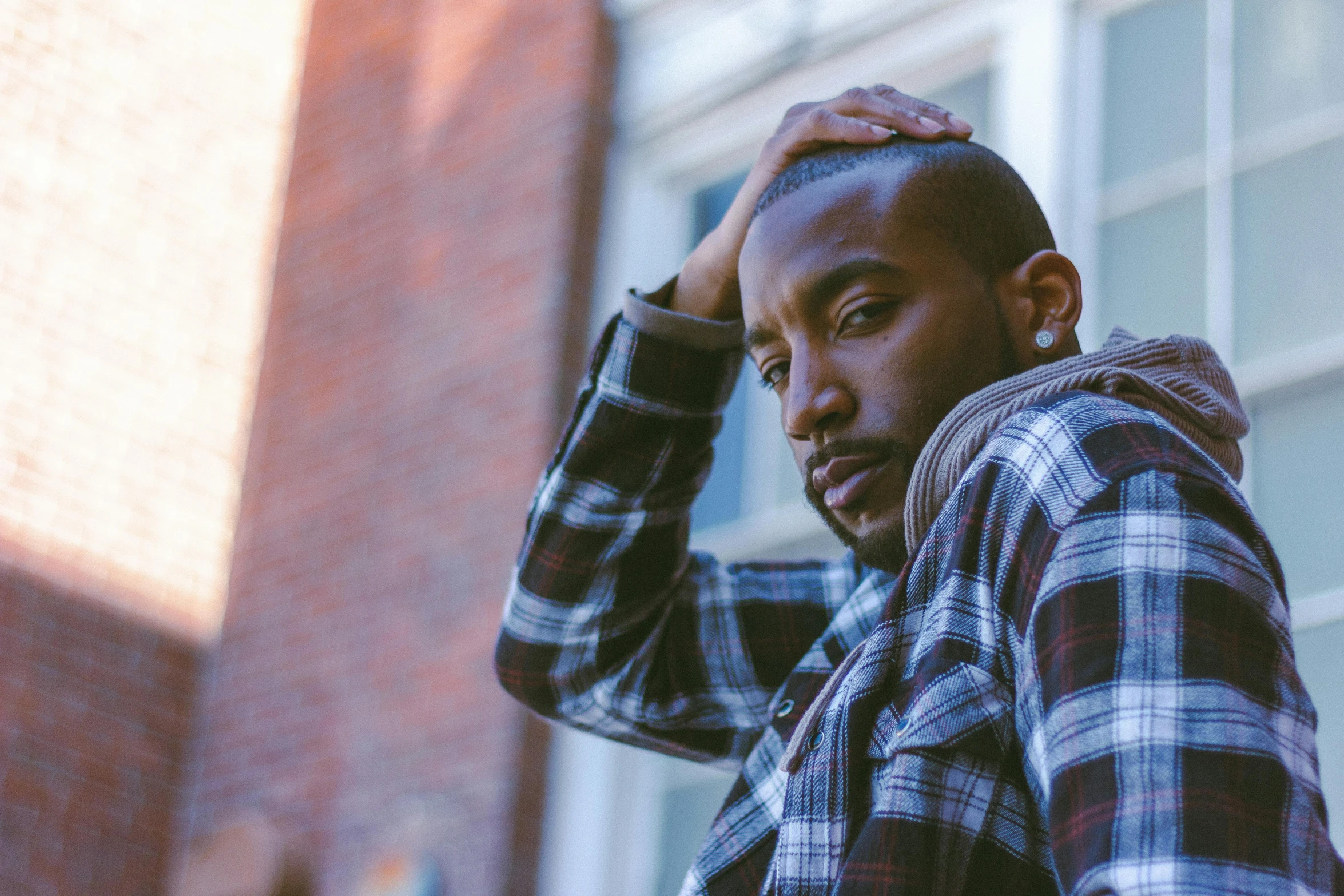 a man in plaid standing next to a building