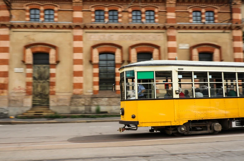 a trolley in a city with many people traveling around