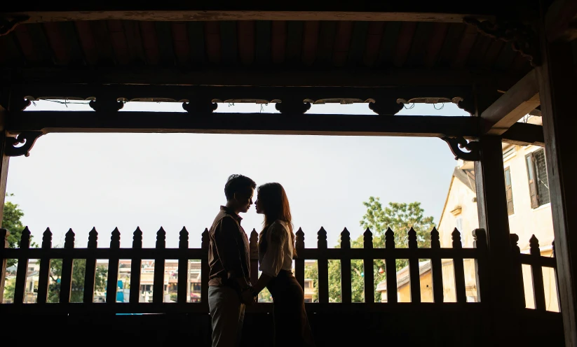 a couple posing for their wedding portrait under an asian pagoda