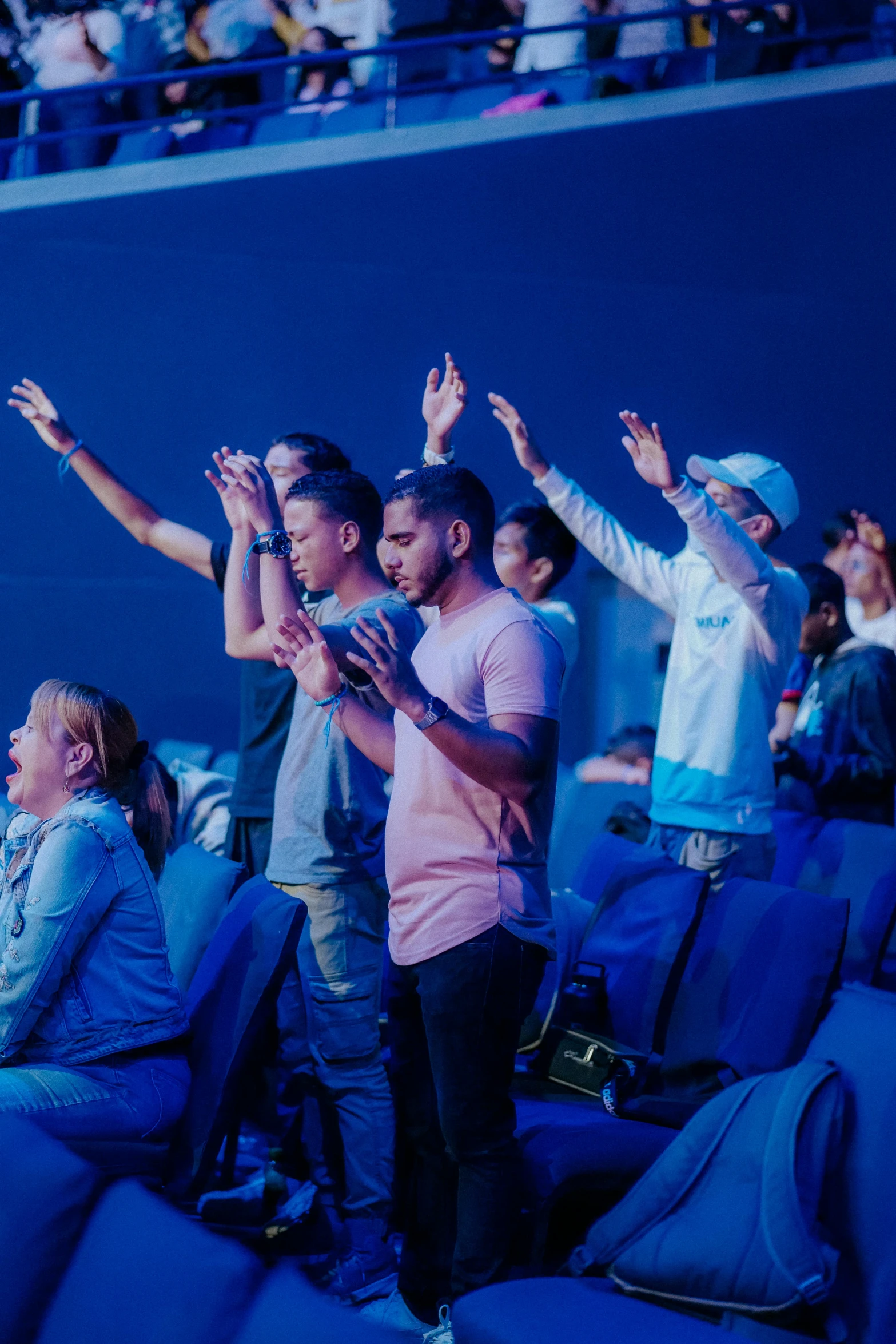 several people standing and clapping on the bleachers