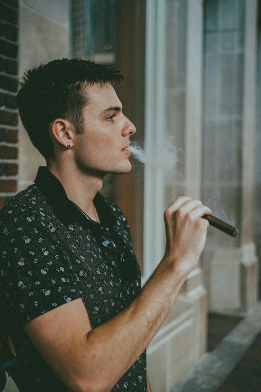 a man standing outside smoking a cigarette