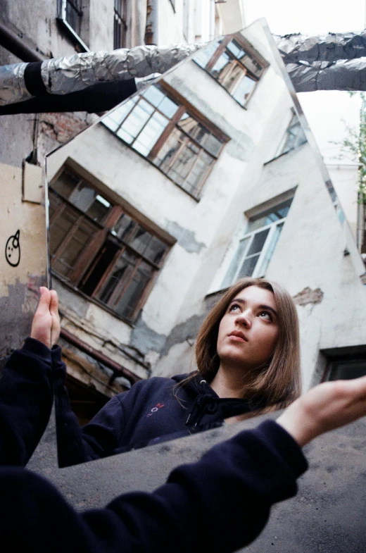 a woman leaning against the side of a building