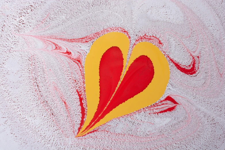 a red and yellow piece of artwork that is shaped like a heart