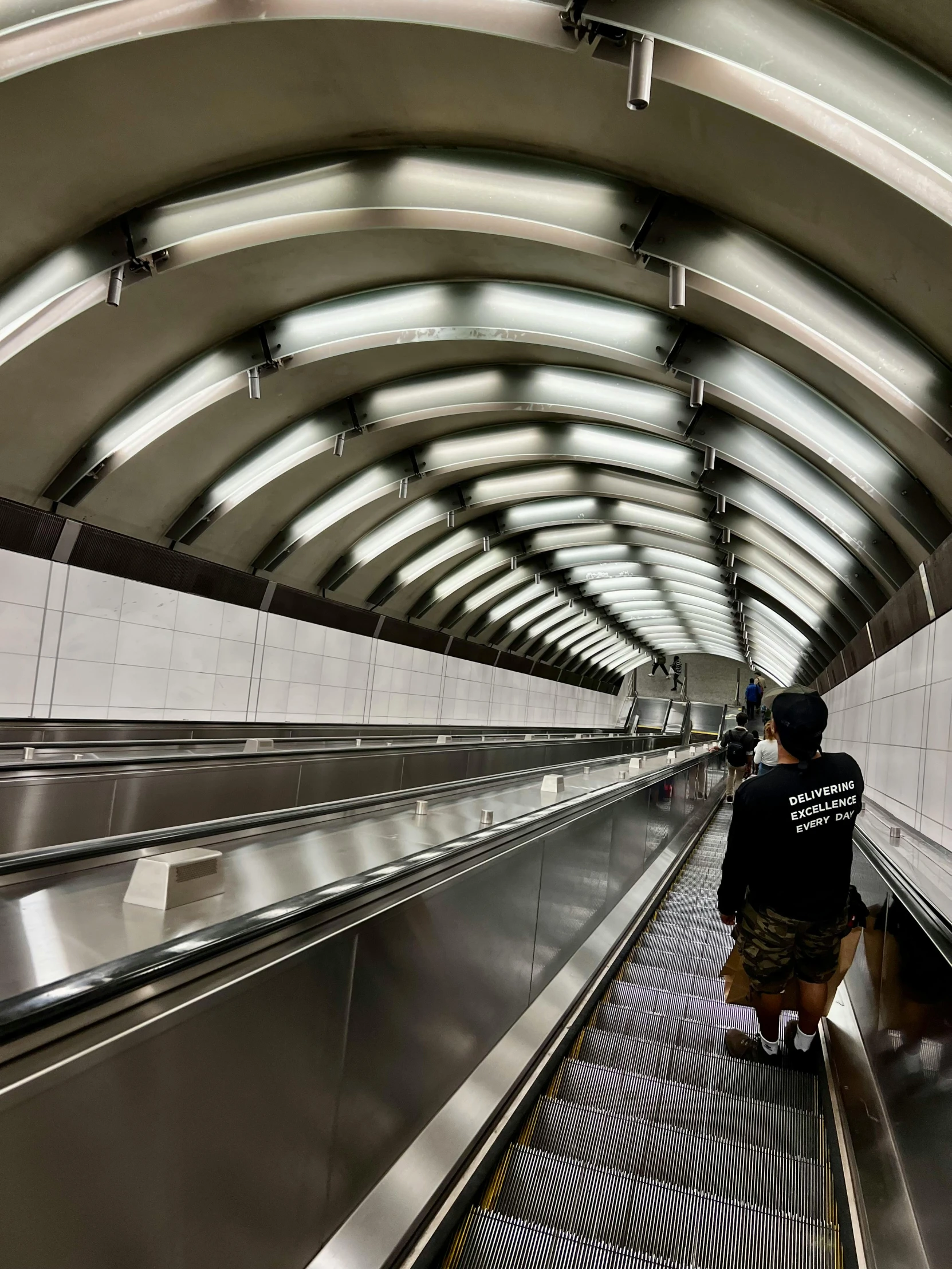 a person is standing on an escalator wearing black and white