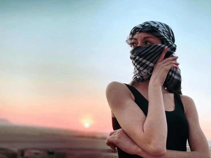 woman standing with her face covered and covering her eyes