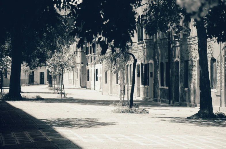 a city street scene with a person sitting on a bench on the side