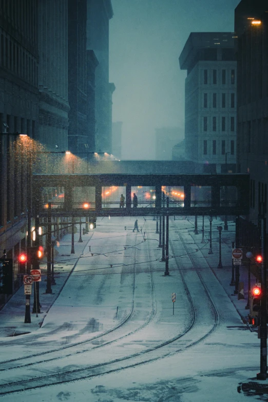 street lights along a snowy city road with train tracks