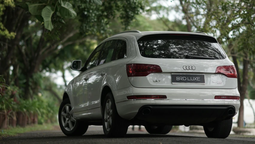 white audi q3 on road near trees