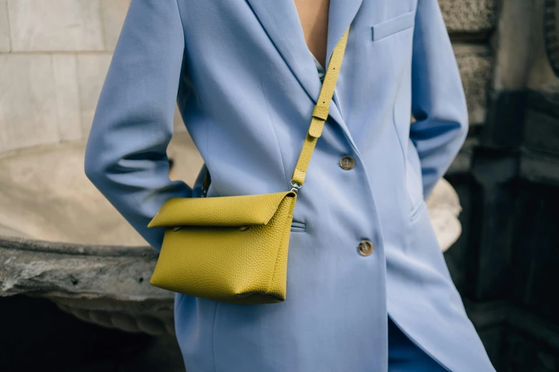 the woman in the blue suit is holding her purse