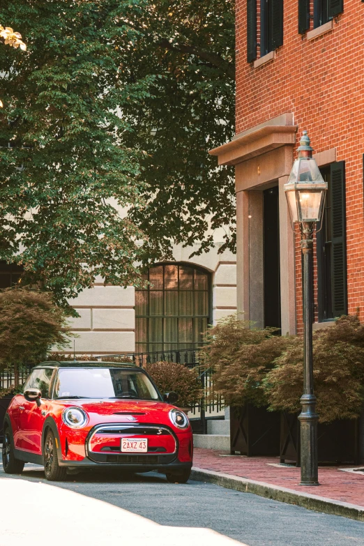 a small red car parked near a tall brick building