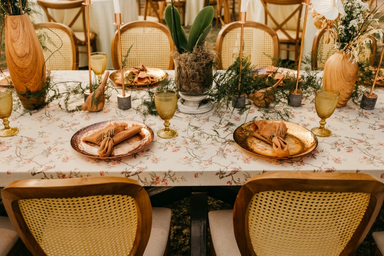 an elegant table setting with gold vases, candle holders, and plates