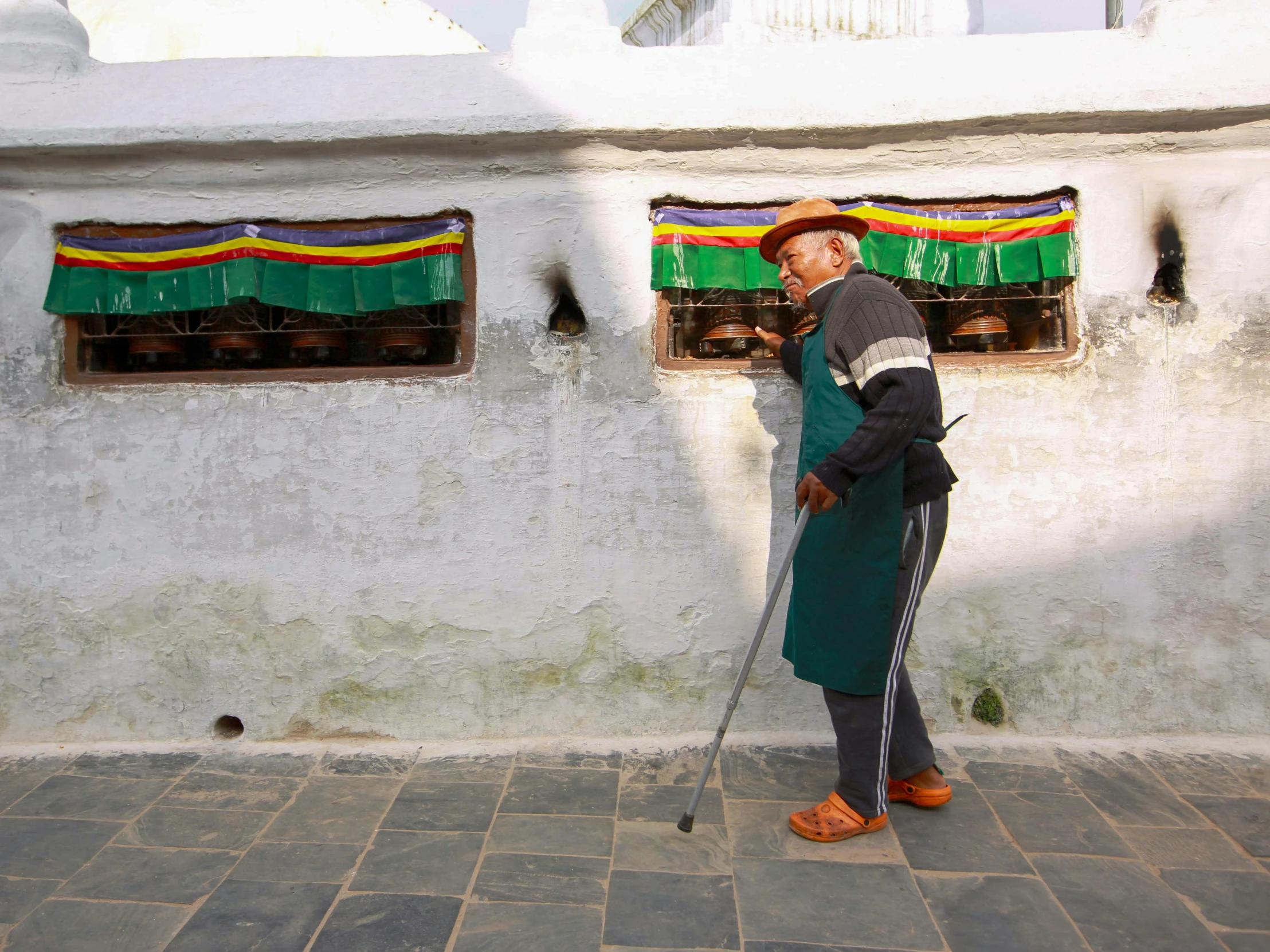 a person holding a cane and looking out from behind