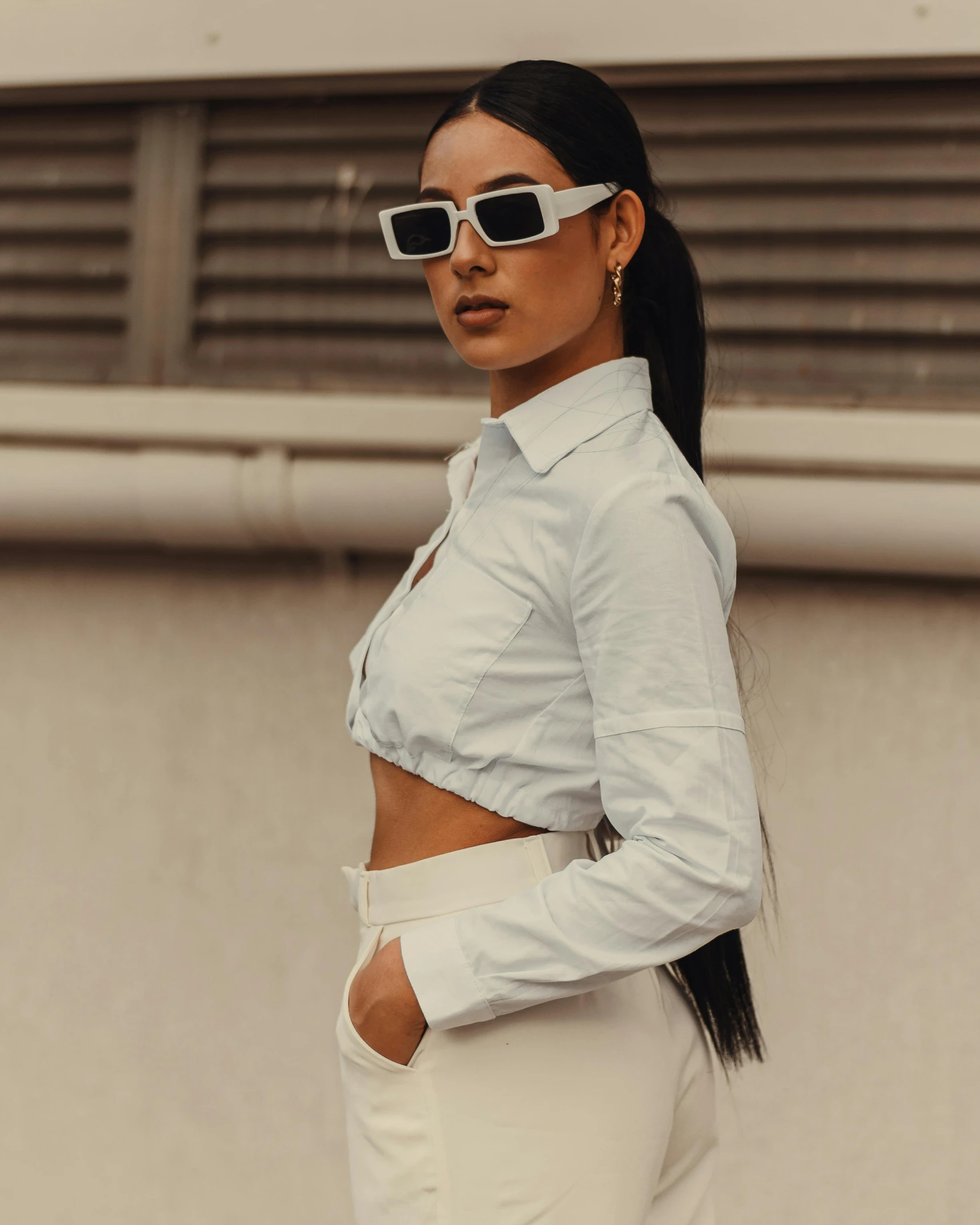 a woman in white pants standing on the street