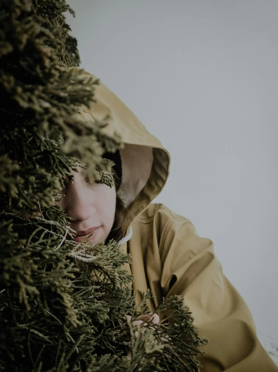 a person hiding behind a tree by herself