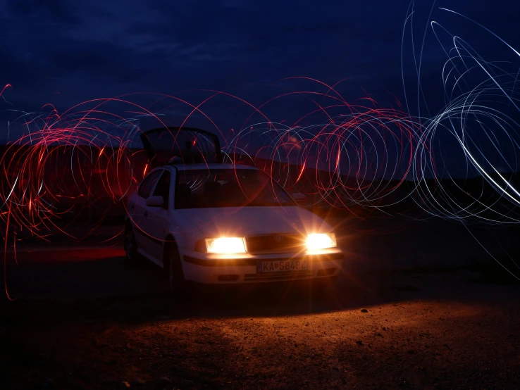 a car parked on the side of the street near some red lights