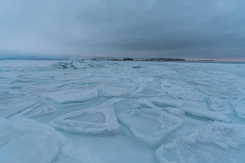 a large expanse of snow with a boat in the distance