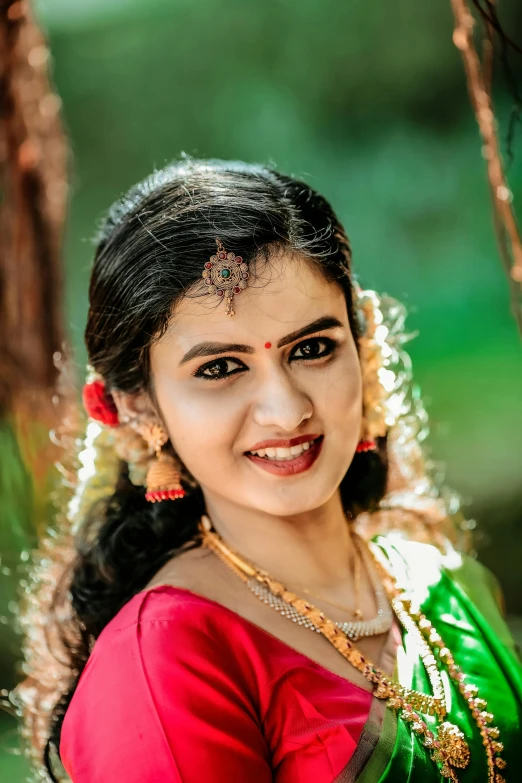 a woman smiles while dressed in a sari