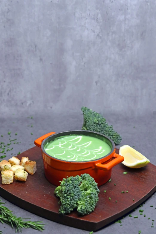 broccoli, lemon wedges, and bread are served on a wooden  board