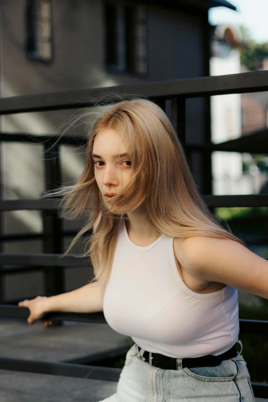 the girl poses on a balcony with her hand outstretched