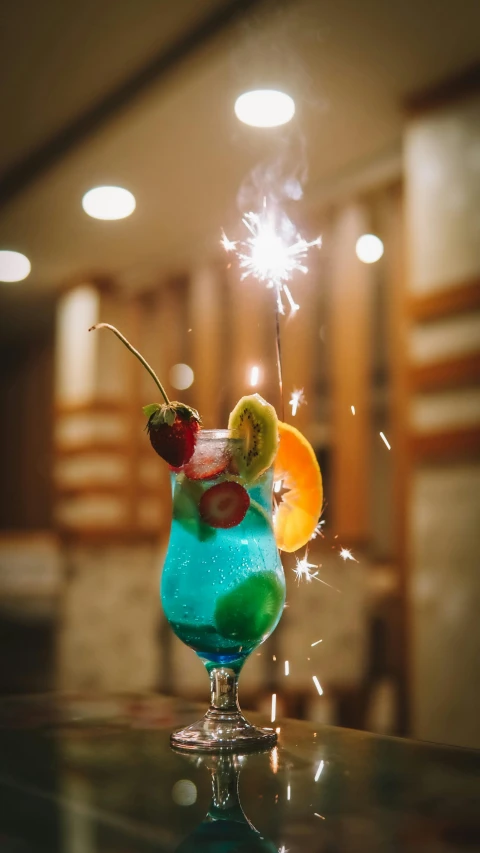 a cocktail drink with a sparkler sitting on a table