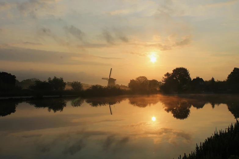 sunset with clouds reflecting off the water and trees