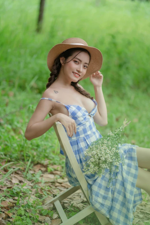 a beautiful young lady in a sun hat and blue dress