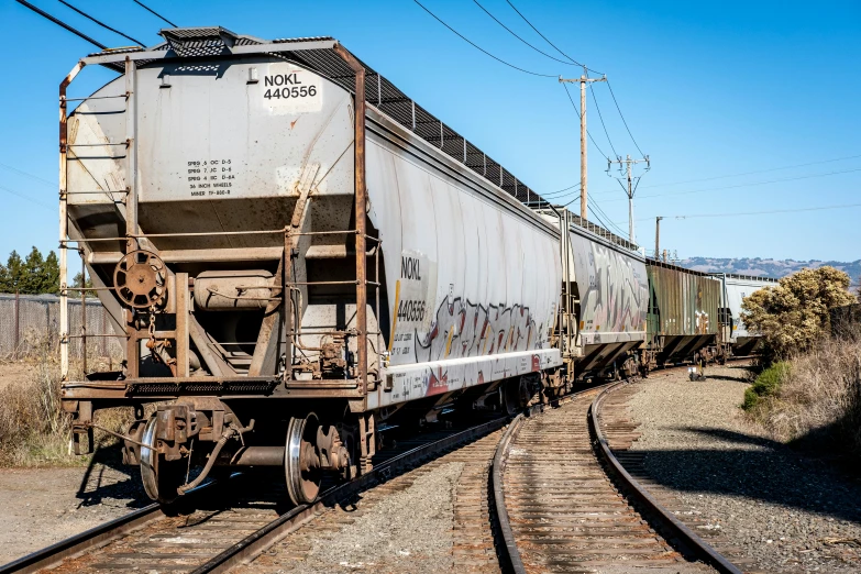 train cars are on the tracks with wires above them