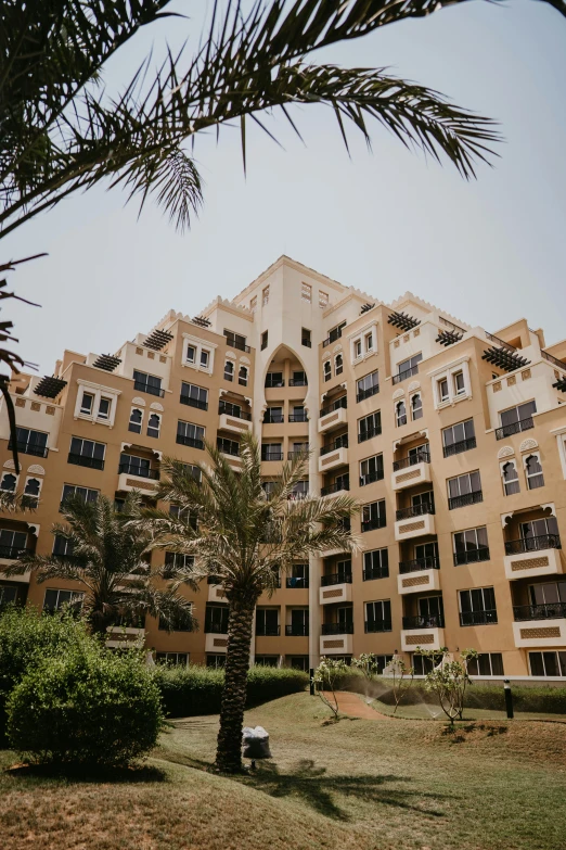 a large building with two windows and green trees around it