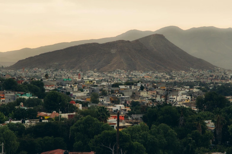 a city with mountains in the background with trees