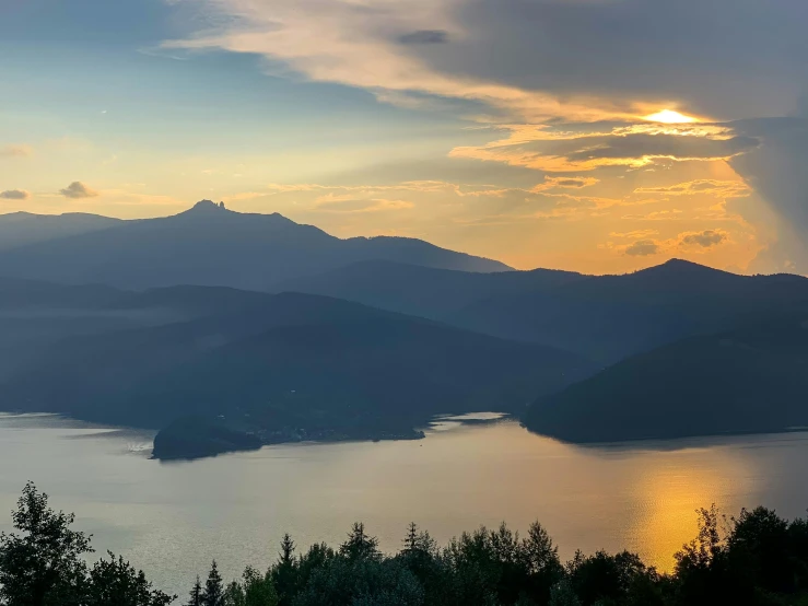 the sun shines through the clouds above the mountains