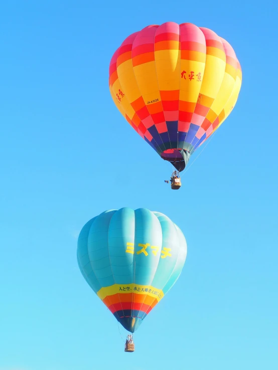 two  air balloons are flying through the sky