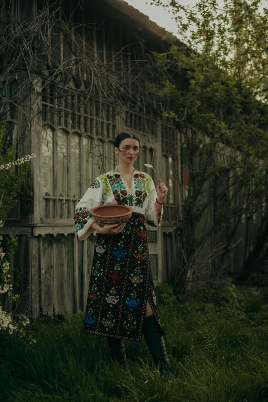 a girl in a colorful dress holding a dish