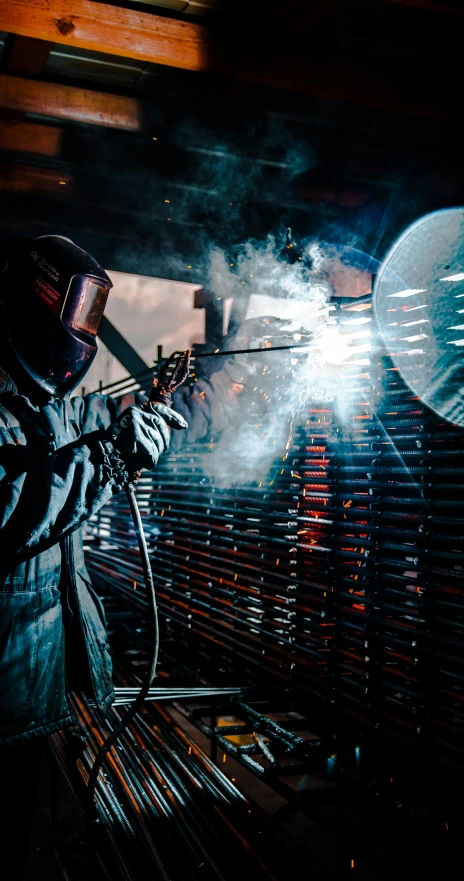 a welder with welding equipment next to some tin plates