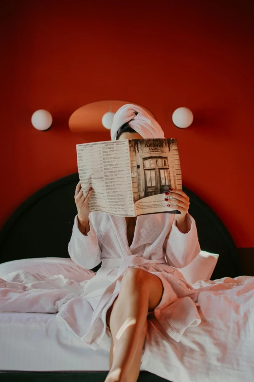 a woman is reading a book on her bed