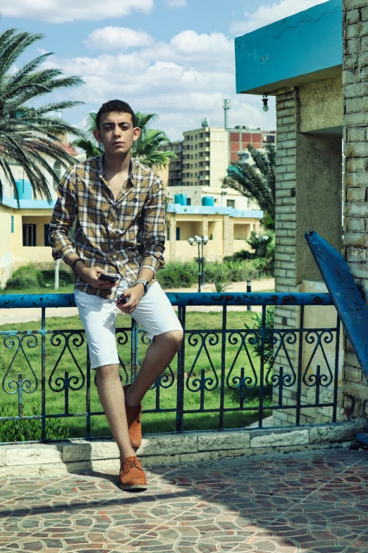 a young man sitting on a metal fence