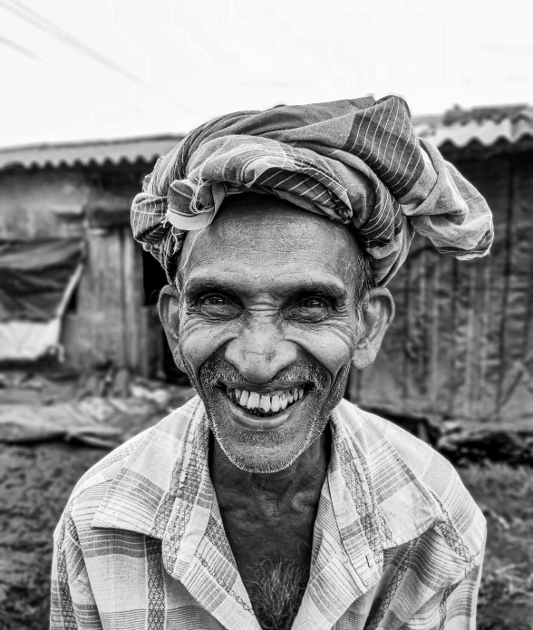 a man is laughing wearing an old fashioned turban