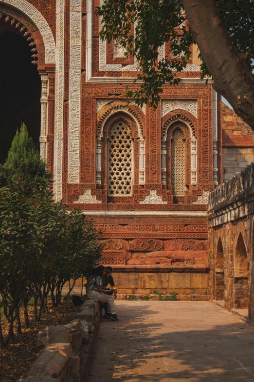 people sitting on benches near an old building