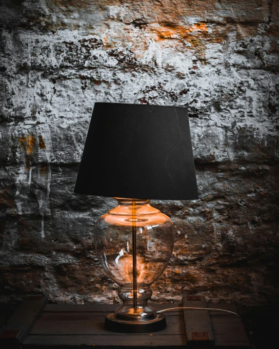 a lamp sitting in front of a wall with some light coming out