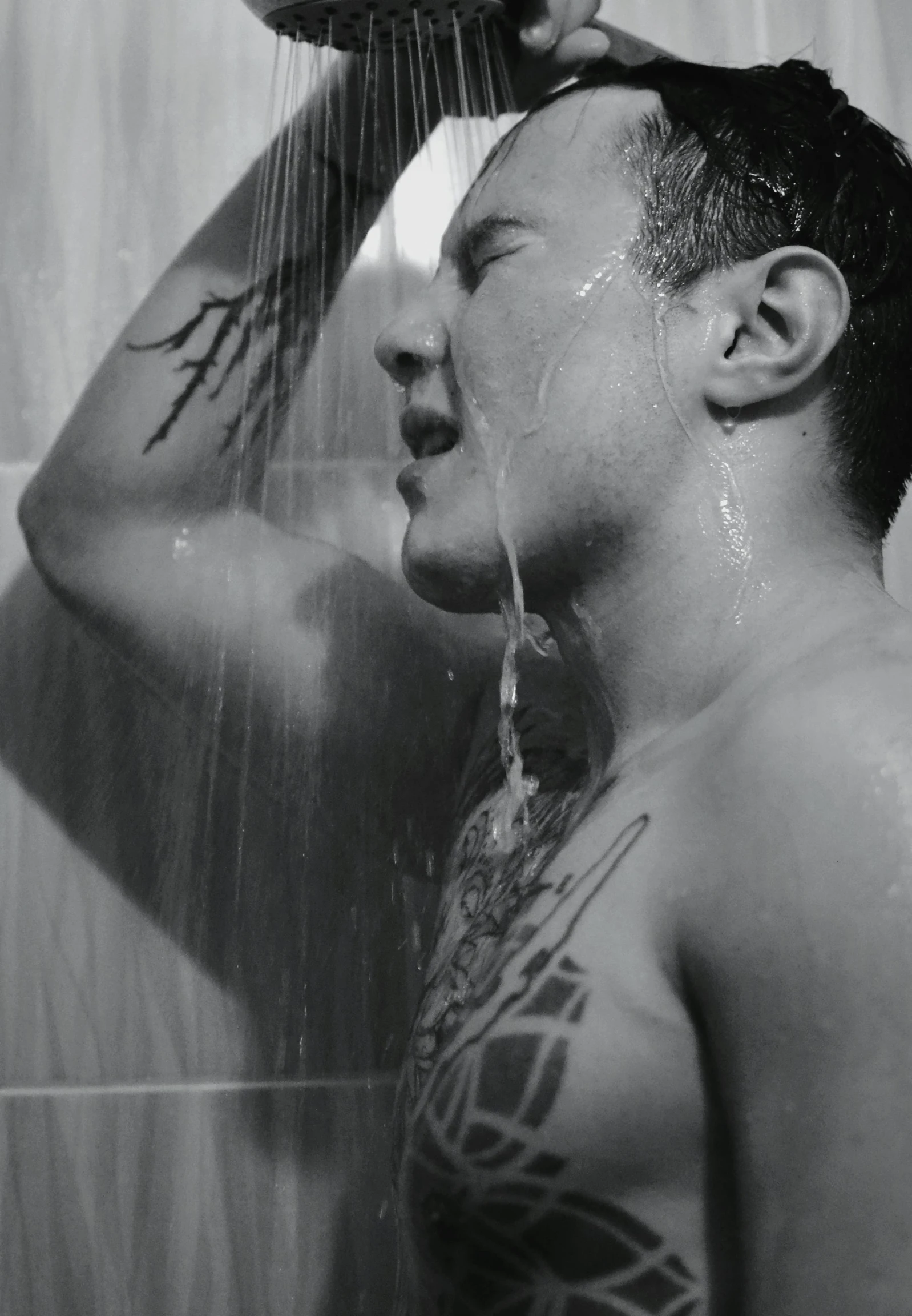 a man taking a shower with a hair dryer on his head