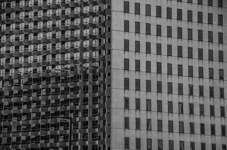 two tall buildings with black windows next to each other