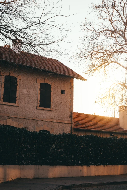 a white house with a hedge and a clock tower