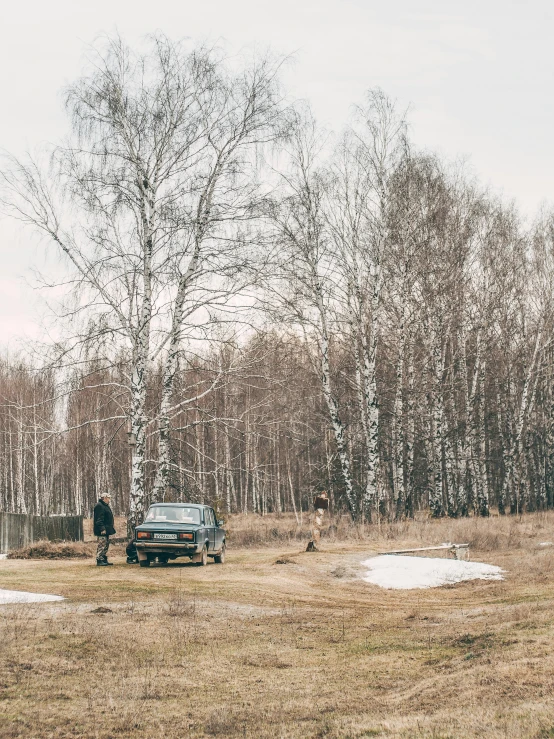 a person standing by a van in an open field