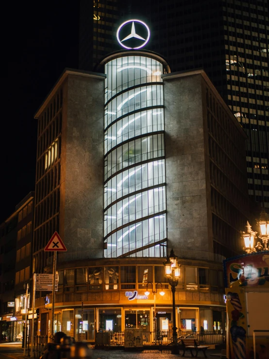 a lighted building with a circular design and glass windows