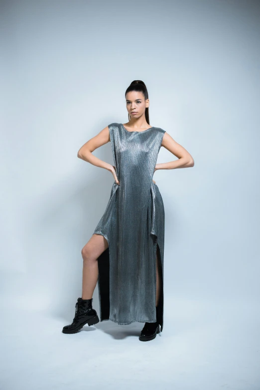 a woman standing on one leg wearing a silver dress