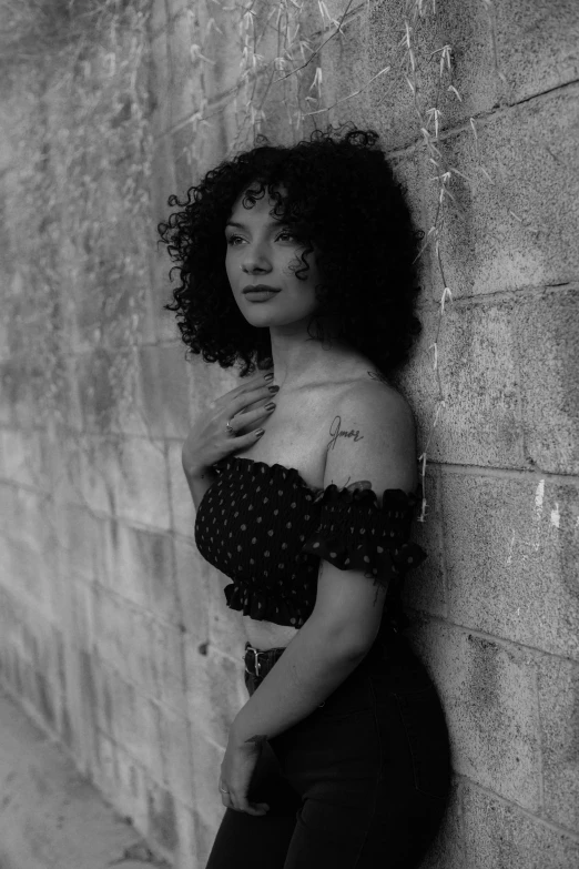 black and white pograph of woman leaning against wall